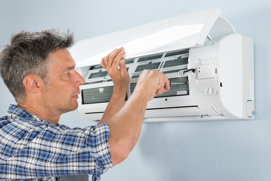 A repairman fixing an air conditioning unit
